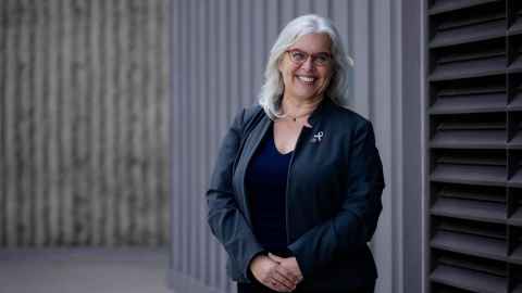 Professor Janet Fanslow in front of a concrete wall.